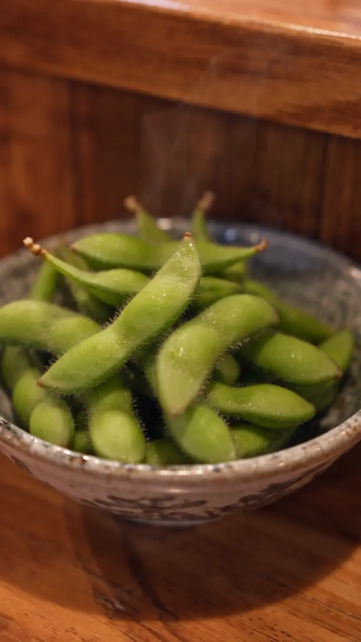 木目のテーブルに置かれた器の枝豆をアップで映した飲食店紹介AI動画